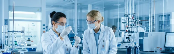 Scientists in white coats working in a pharmaceutical laboratory